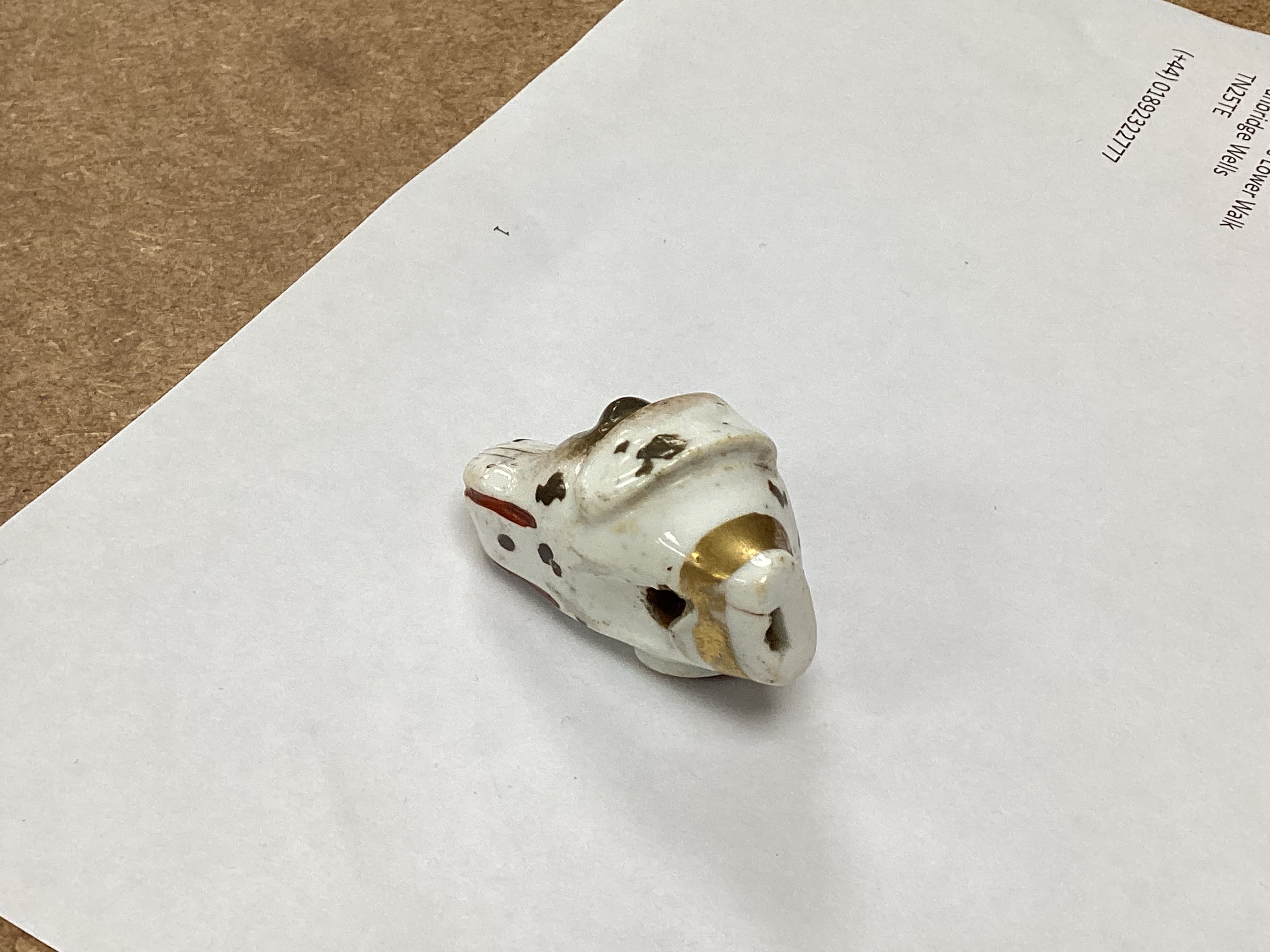 An early 19th century Staffordshire porcelain dog’s head whistle, 4.5cm